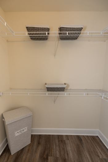 A white shelf with two baskets and a box on it.